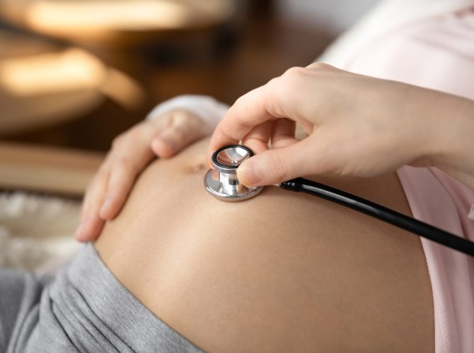 Crop,Close,Up,Of,Doctor,Hold,Stethoscope,Listen,To,Pregnant